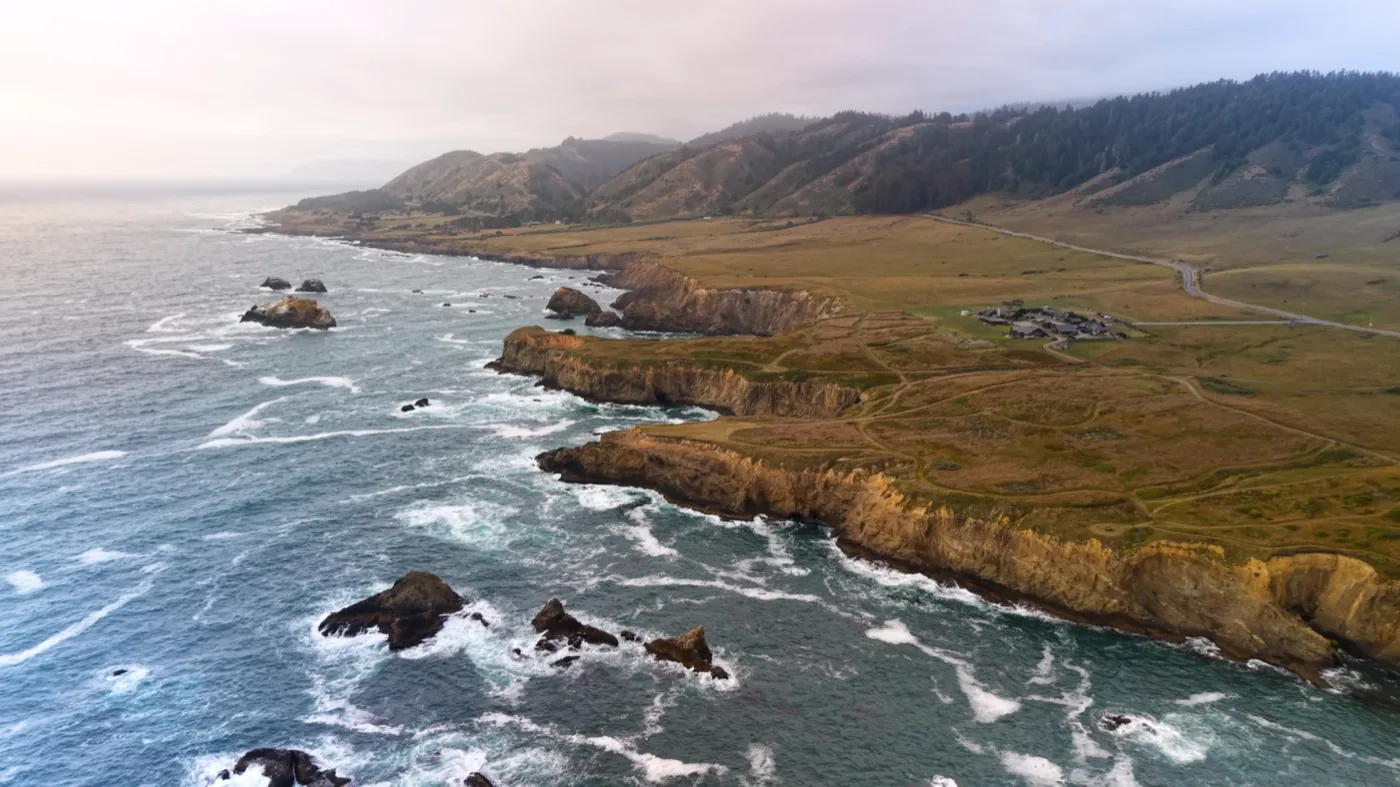 Wide aerial view of The Inn at Newport Ranch, coastal bluffs and Pacific Ocean on the Mendocino Coast